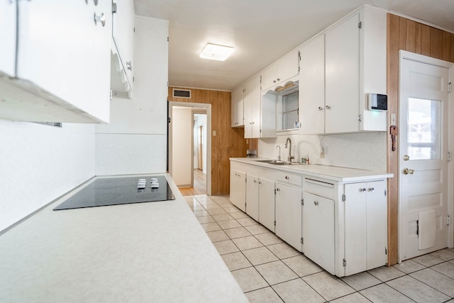 kitchen featuring sink, black electric cooktop, white cabinetry, and light tile patterned flooring