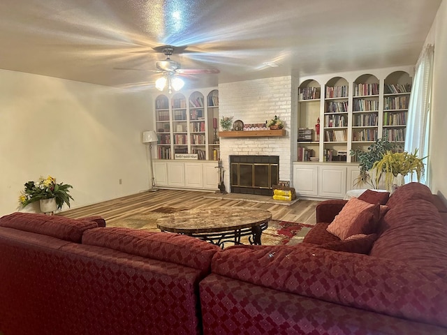 living room featuring ceiling fan, wood-type flooring, and a fireplace