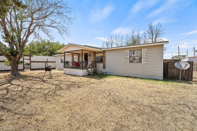 back of property featuring covered porch