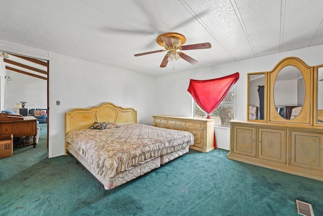 carpeted bedroom featuring ceiling fan and a textured ceiling