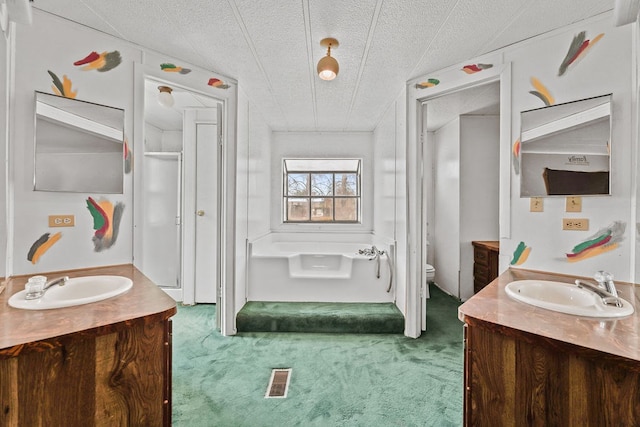 bathroom featuring vanity, a textured ceiling, and toilet