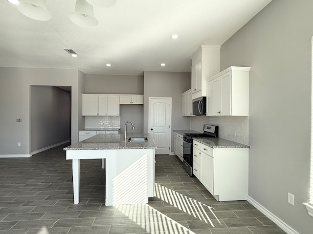 kitchen with a center island with sink, sink, white cabinetry, and stainless steel appliances