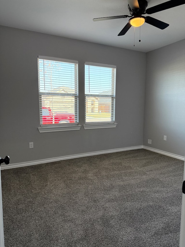 unfurnished room with ceiling fan, plenty of natural light, and dark colored carpet