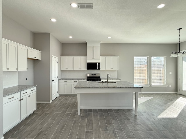 kitchen featuring light stone countertops, white cabinets, dark hardwood / wood-style floors, and appliances with stainless steel finishes