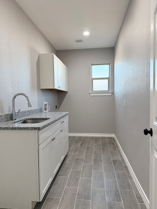 laundry room featuring hookup for an electric dryer, washer hookup, cabinets, and sink