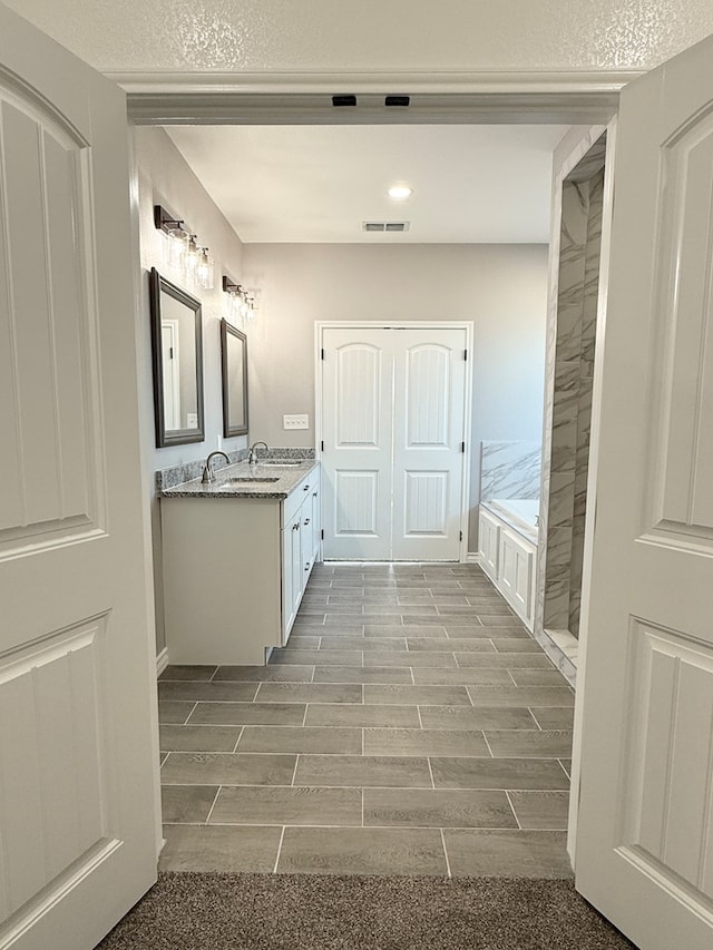 bathroom featuring vanity and a bath