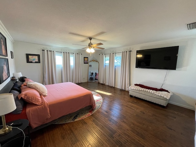 bedroom featuring a textured ceiling, dark hardwood / wood-style flooring, ceiling fan, and ornamental molding