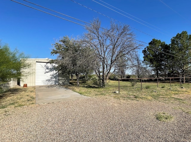 view of yard featuring a garage and an outbuilding