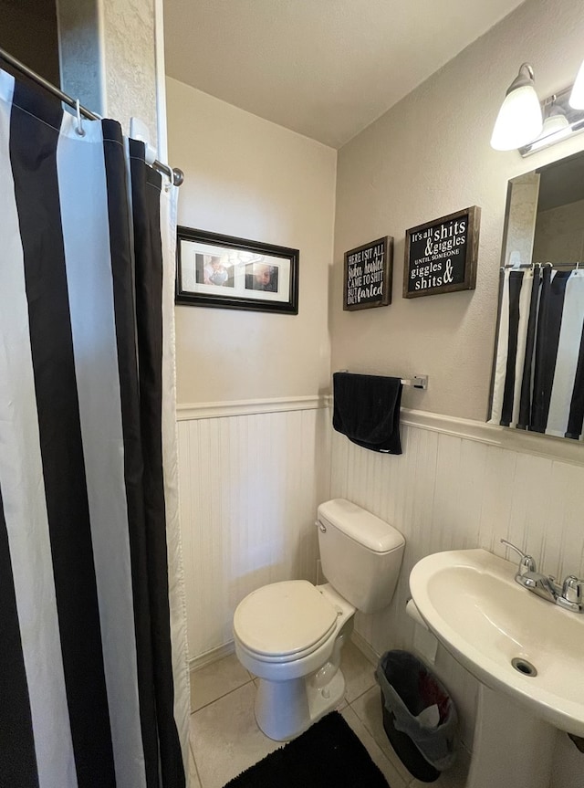 bathroom featuring tile patterned flooring, toilet, and sink