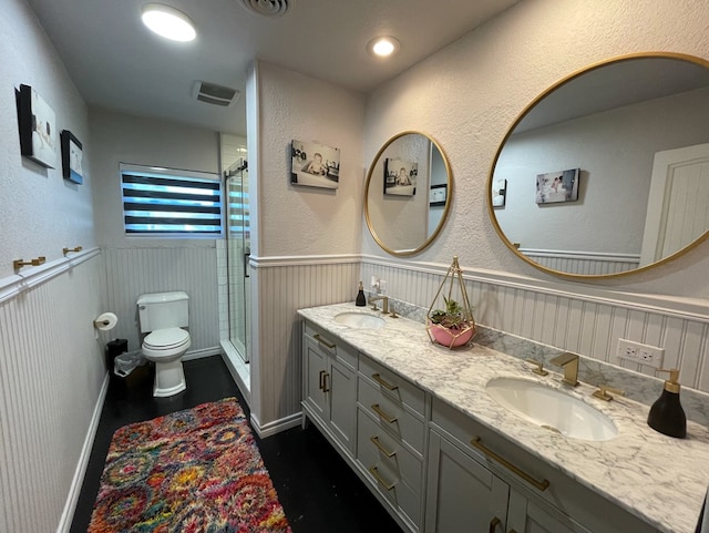 bathroom featuring vanity, toilet, and a shower with door