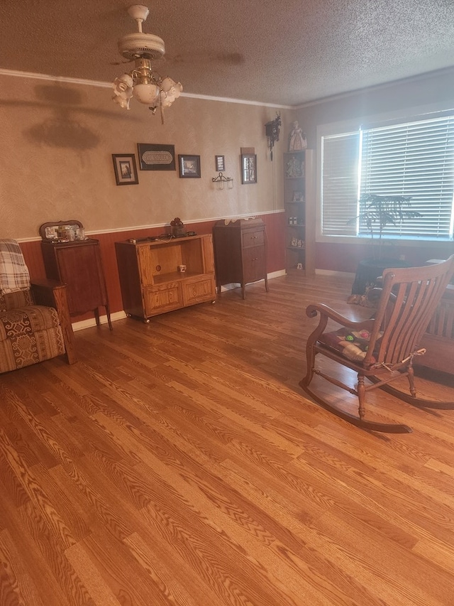 unfurnished living room featuring ceiling fan, light hardwood / wood-style floors, and a textured ceiling