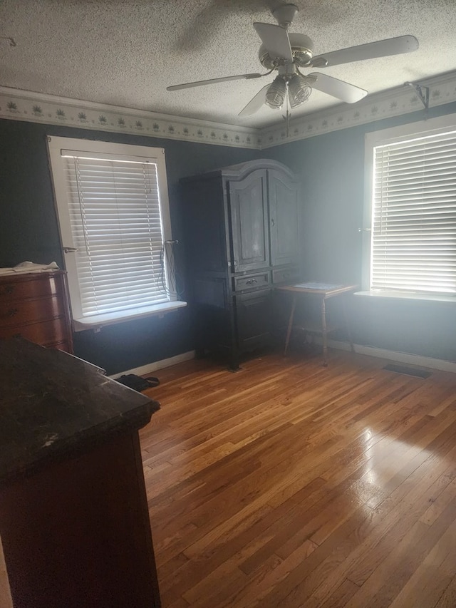 bedroom featuring ceiling fan, a textured ceiling, and hardwood / wood-style flooring