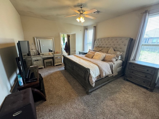 carpeted bedroom featuring ceiling fan and multiple windows