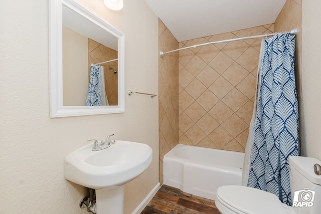 full bathroom featuring hardwood / wood-style flooring, toilet, shower / bathtub combination with curtain, and sink