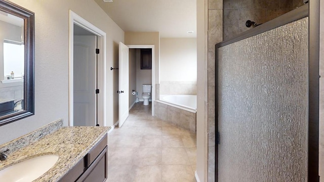 bathroom featuring tile patterned floors, toilet, a stall shower, a bath, and vanity