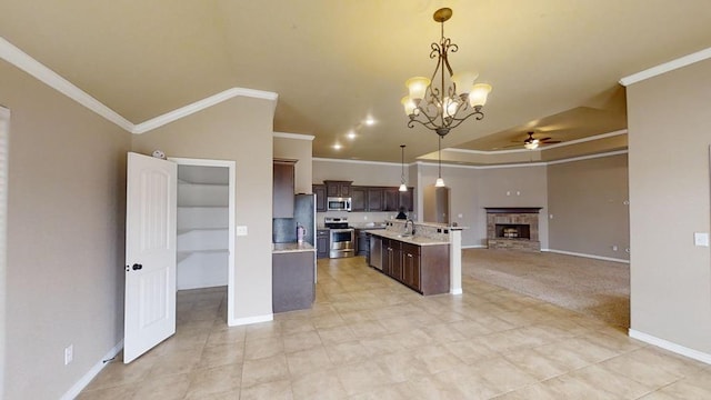 kitchen featuring dark brown cabinetry, open floor plan, light countertops, stainless steel appliances, and a sink