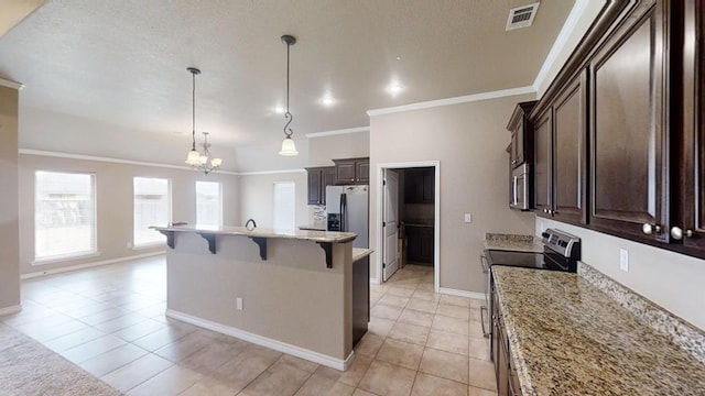 kitchen featuring dark brown cabinets, visible vents, appliances with stainless steel finishes, and a breakfast bar