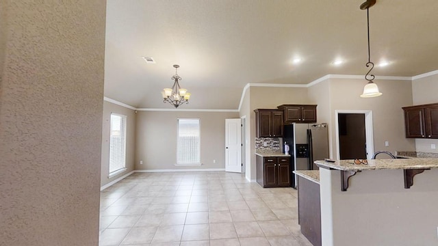 kitchen featuring ornamental molding, a kitchen breakfast bar, tasteful backsplash, dark brown cabinetry, and stainless steel fridge with ice dispenser