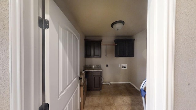 washroom featuring hookup for a washing machine, light tile patterned flooring, cabinet space, and baseboards