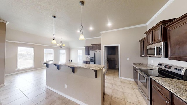 kitchen with a breakfast bar, a kitchen island with sink, ornamental molding, stainless steel appliances, and dark brown cabinets