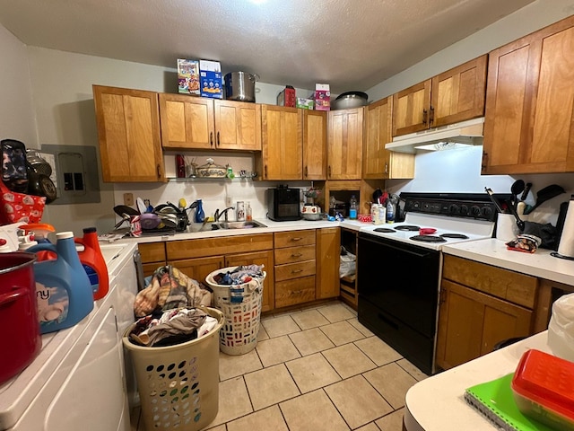 kitchen with range with electric stovetop, sink, light tile patterned floors, washing machine and dryer, and a textured ceiling