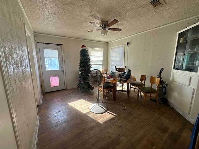 dining space with ceiling fan, ornamental molding, dark hardwood / wood-style flooring, and a textured ceiling