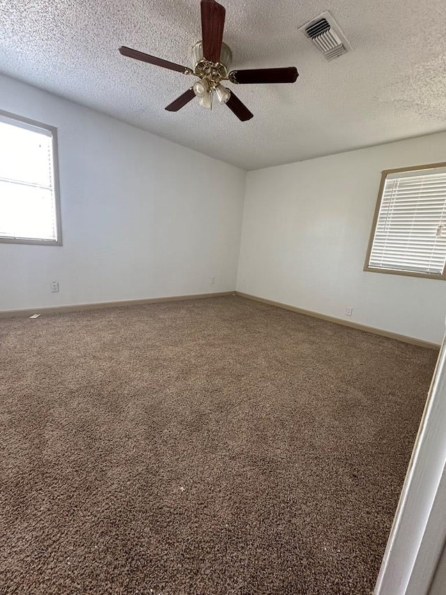 unfurnished room with carpet flooring, ceiling fan, and a textured ceiling