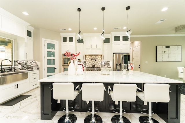 kitchen with hanging light fixtures, stainless steel appliances, light stone counters, and a spacious island