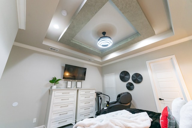 bedroom with a raised ceiling and crown molding