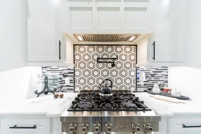 kitchen featuring light stone countertops, tasteful backsplash, and white cabinetry