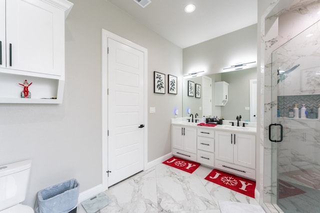 bathroom with toilet, vanity, and a shower with shower door