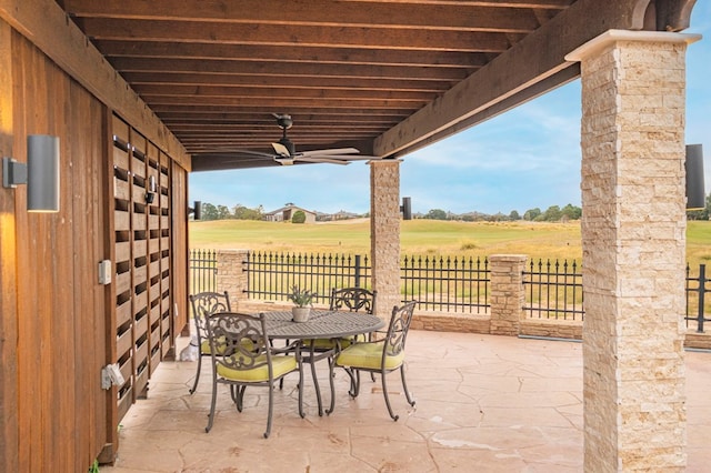 view of patio / terrace with ceiling fan and a rural view