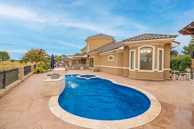 view of swimming pool featuring pool water feature, a patio area, and an in ground hot tub