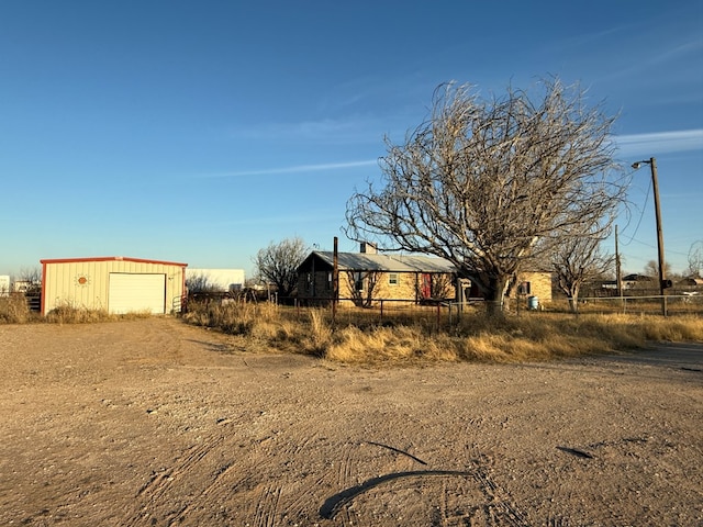 view of yard featuring a garage and an outbuilding