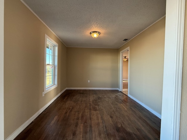 unfurnished room featuring dark hardwood / wood-style flooring and a textured ceiling