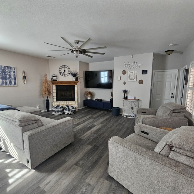 living room with dark hardwood / wood-style flooring, ceiling fan, and a textured ceiling