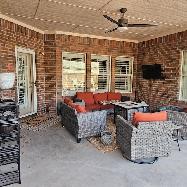 view of patio featuring ceiling fan and an outdoor living space with a fire pit