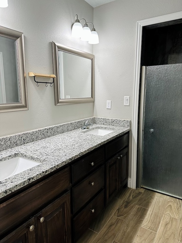 bathroom with walk in shower, vanity, and hardwood / wood-style flooring