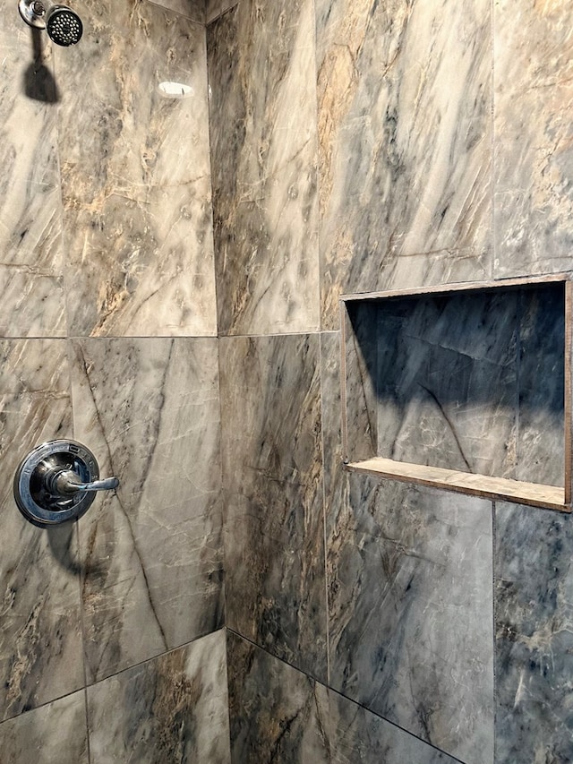 interior details featuring a tile shower