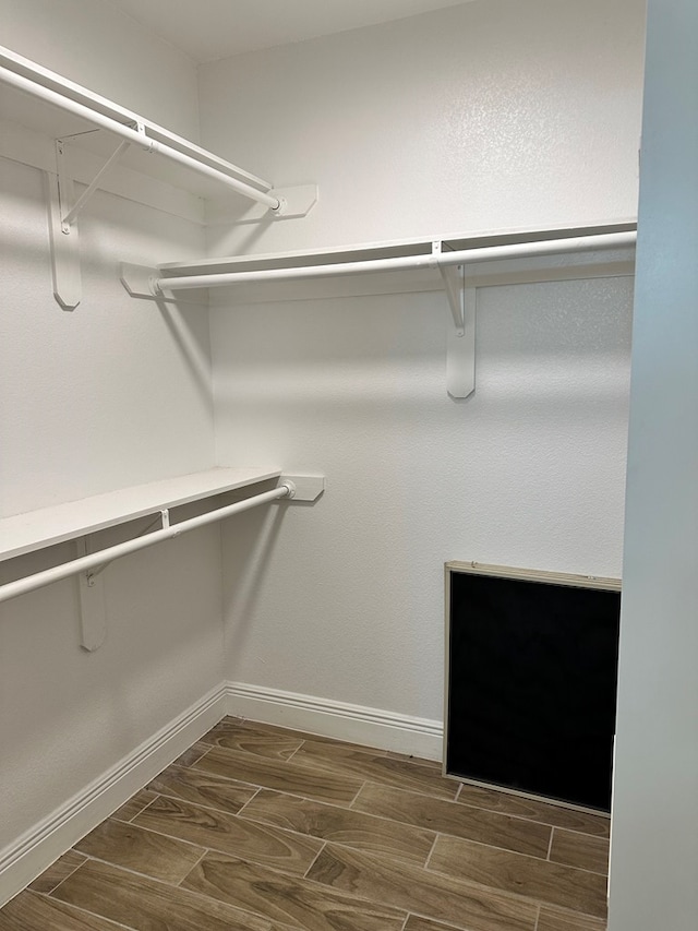 spacious closet featuring dark hardwood / wood-style flooring