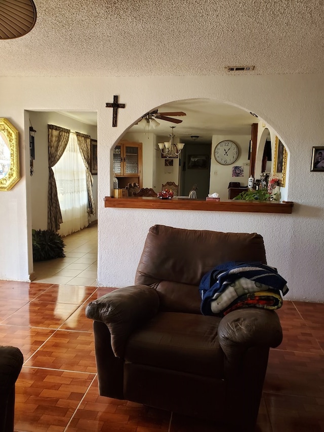 living room with ceiling fan, hardwood / wood-style flooring, and a textured ceiling