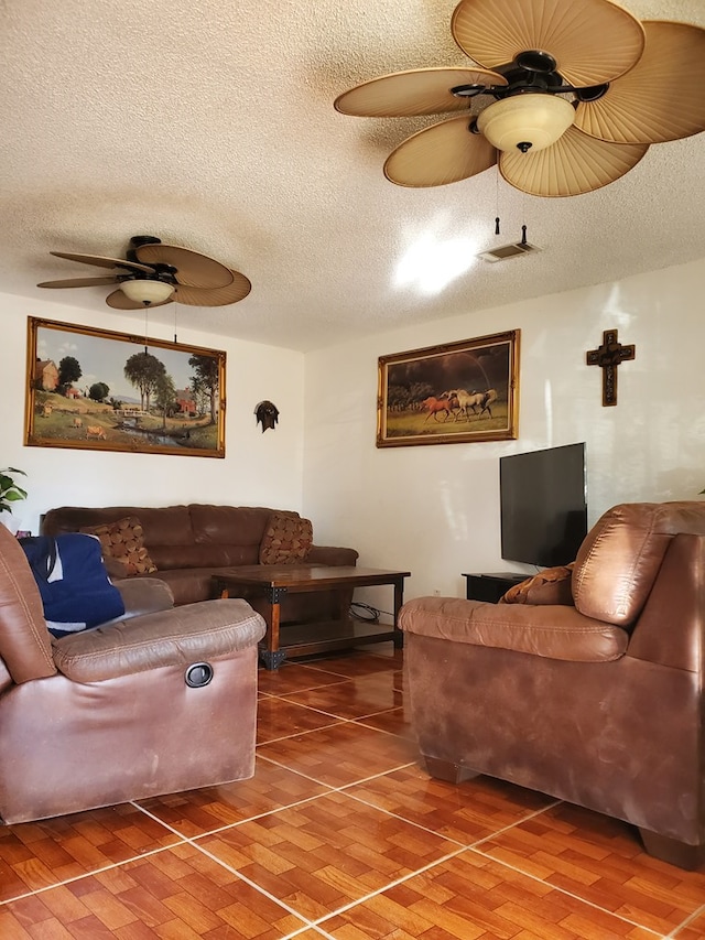 living room with hardwood / wood-style flooring, a textured ceiling, and ceiling fan