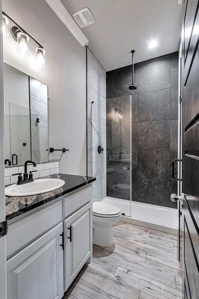 bathroom with vanity, toilet, and walk in shower