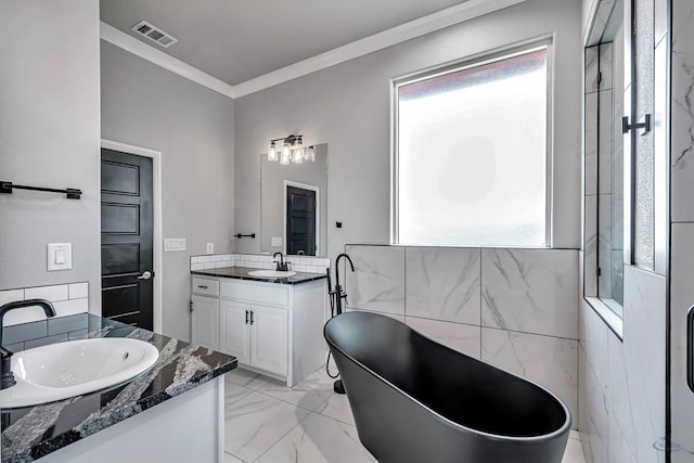 bathroom featuring crown molding, vanity, and a washtub