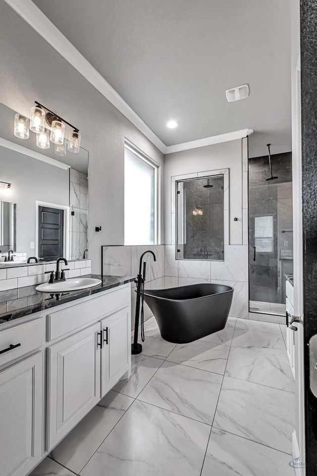 bathroom featuring plus walk in shower, tile walls, vanity, and crown molding