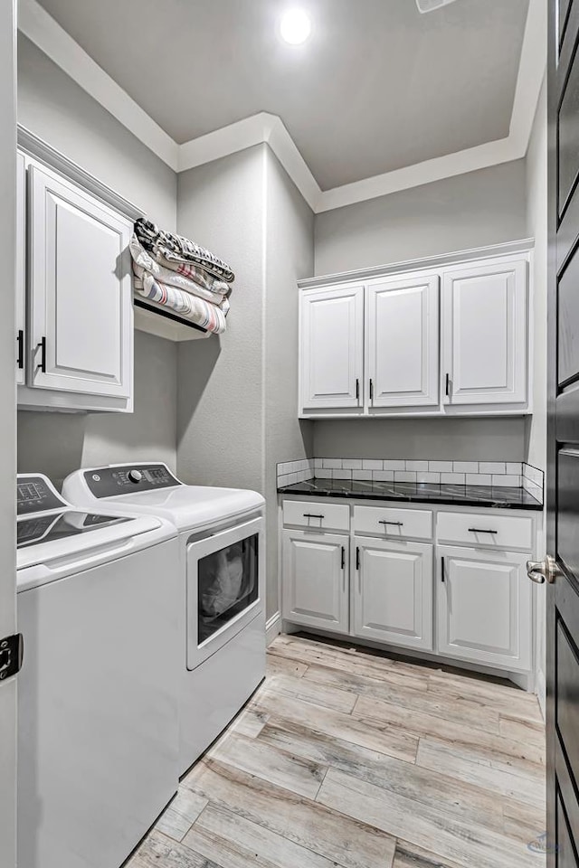 clothes washing area with cabinets, ornamental molding, separate washer and dryer, and light hardwood / wood-style flooring