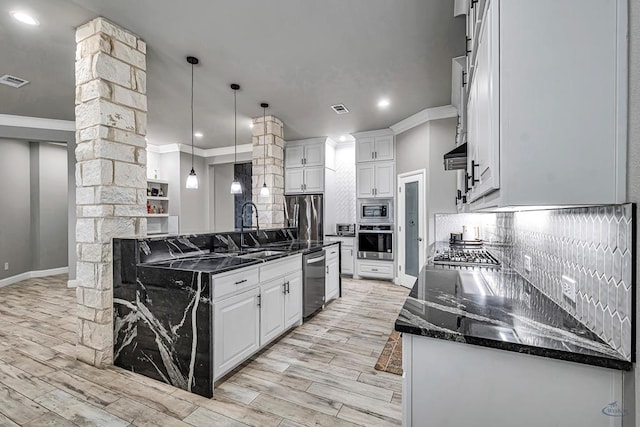 kitchen featuring dark stone countertops, sink, white cabinets, and appliances with stainless steel finishes