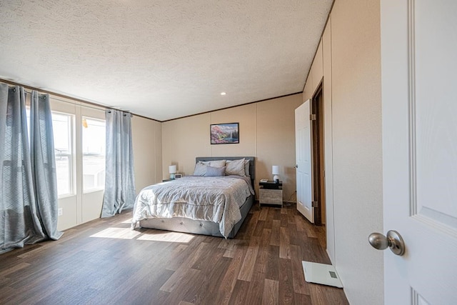 bedroom featuring a textured ceiling and dark hardwood / wood-style flooring