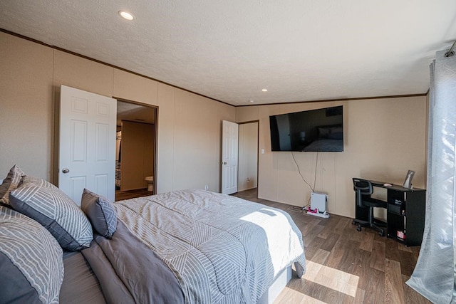 bedroom with dark wood-type flooring, ornamental molding, and a textured ceiling