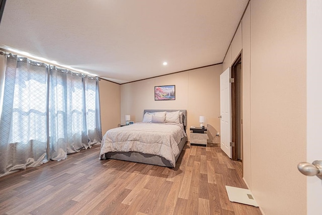 bedroom featuring light hardwood / wood-style flooring and ornamental molding